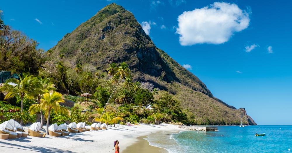 St. Lucia - Frau am Strand mit Gebirge im Hintergrund